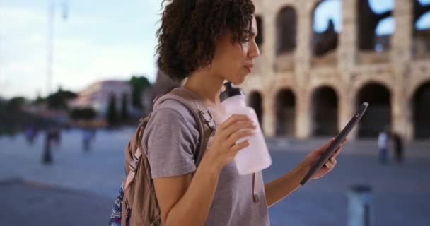 Atraente Fêmea Negra Usa Tablet Perto Coliseu Romano Bebendo Água — Vídeo de Stock