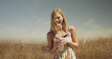 açık havada kameraya gülümseyen genç bir kadın