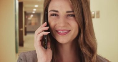 Akıllı telefondan konuşan güzel bir iş kadını. Mutlu, kendinden emin ve başarılı bir kadın müşterilerle konuşuyor..