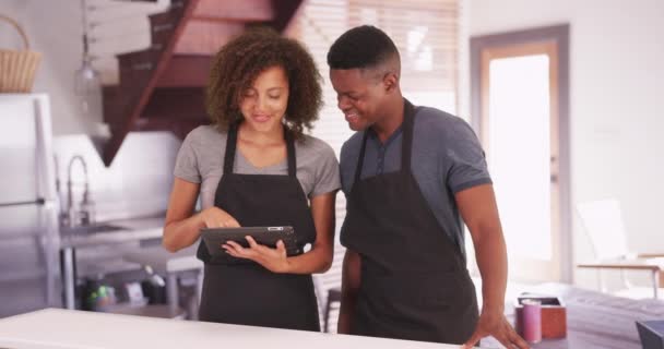 黑人男女在平板电脑上计划他们的食谱 非裔美国人千年夫妇开始在他们的现代厨房里用垫子做饭 — 图库视频影像