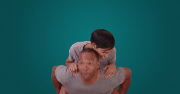 一对非洲裔美国人夫妇在蓝色背景下互相搭便车 一个黑人男人和一个女人在一个空白的背景上互相跳着 — 图库视频影像