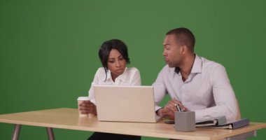 İki iş adamı yeşil ekranda dizüstü bilgisayarda birlikte çalışıyor. Anahtar ya da birleşik olmak üzere yeşil ekranda.