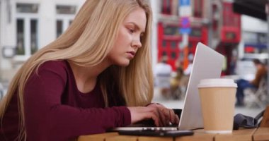 Modern beyaz kadın, Belçika 'nın Bruges kentindeki bir kafede internetten e-postalarını kontrol ediyor. Sarışın, beyaz kadın dışarıda bilgisayarında vakit geçiren Bruges 'ü geziyor. 4k