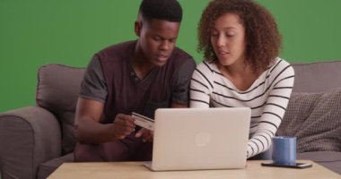 Mutlu Siyah Milenyum çifti yeşil ekrandan alışveriş yapıyor. Anahtar ya da birleşik olmak üzere yeşil ekranda.