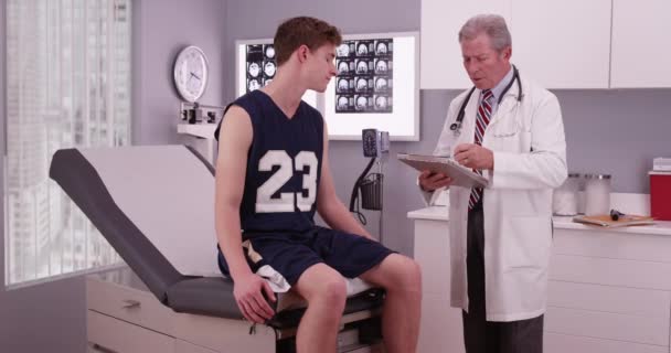 若い男性スポーツ選手が医者の診療所で — ストック動画