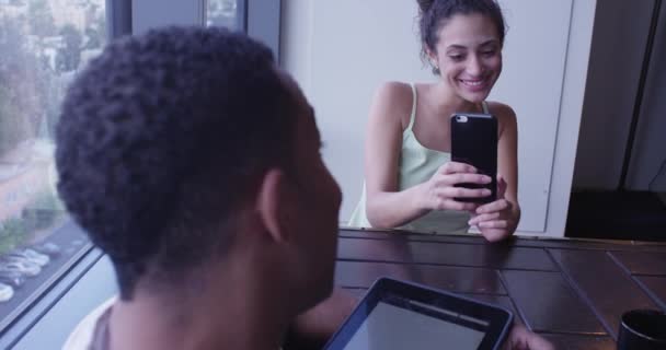 拉丁裔和黑人夫妇在客厅里使用智能手机和平板电脑拍照 — 图库视频影像