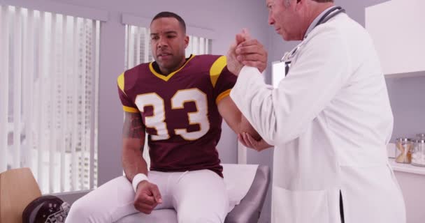 大学フットボール選手が肘の検査を受けた上級医師 — ストック動画