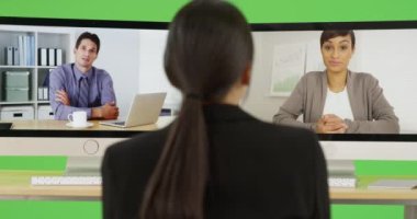 Genç bir iş kadını iş arkadaşlarıyla yeşil ekranda sohbet ediyor. Anahtar ya da birleşik olmak üzere yeşil ekranda.