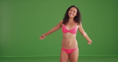 Yeşil ekranda bikini giymiş, gülümseyen seksi melez kadın. Anahtarlama veya birleştirme için yeşil ekranda.