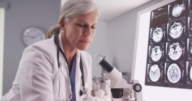 Olgun beyaz nörolog bakarak kadın x-ışınları