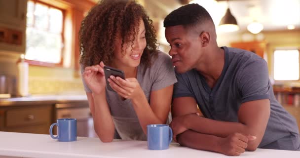 千年黑人男女在厨房喝咖啡时一起探索社交媒体 非洲裔美国人夫妇在吃完早餐后使用智能手机 — 图库视频影像