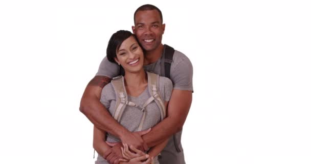 一对非裔美国夫妇抱在一起 穿着白色背景的登山服 一个黑人男人和女人在一个空白的背景上摆姿势要求画像时拥抱在一起 — 图库视频影像