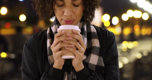 一个漂亮的非裔美国女人在户外咖啡馆拿着咖啡杯的特写镜头 在晚上 在巴黎街头享受热饮的年轻女子的特写 — 图库视频影像