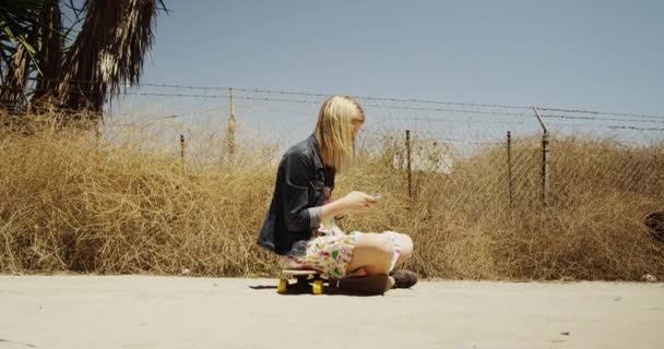 Blonde Woman Sitting Skateboard Texting — Stock Video
