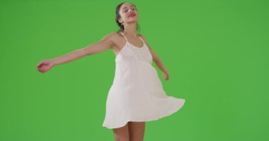 Latin bir kız yeşil ekranda elbisesiyle dönüyor. Anahtar ya da birleşik olmak üzere yeşil ekranda.