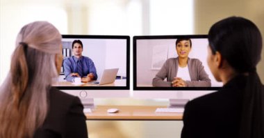 Ofis profesyonellerinden oluşan bir ekip görüntülü konuşma yapıyor. İki iş kadını iş arkadaşlarıyla konuşur. 4k