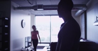 Romantik İspanyol ve siyahi çiftin dairede öpüşüp kucaklaşmalarının silueti.