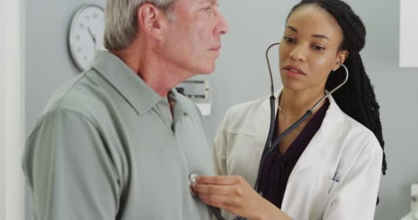 高齢者の患者の呼吸を聴いて黒人女性医師 — ストック動画