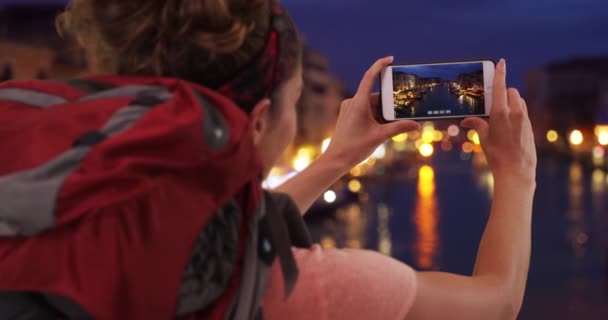 イタリアのヴェネツィアで携帯電話のカメラで大運河の写真を記録した冒険的な白い女性 ヴェネツィアでの夜の電話で撮影女性バックパッカー — ストック動画