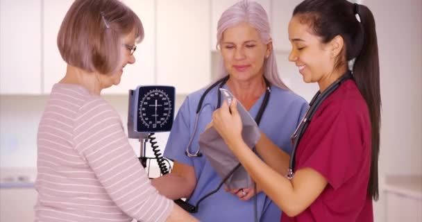 Nővér Tanuló Hogy Ellenőrizze Beteg Vérnyomását Klinikán Két Orvos Ellenőriz — Stock videók