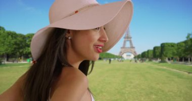 Eiffel Kulesi 'nin yakınlarına bakıp gülümseyen çekici Latin turistlere yakın durun. İspanyol kadın Paris 'teki şehir parkında güzel bir günün tadını çıkarıyor. 4k