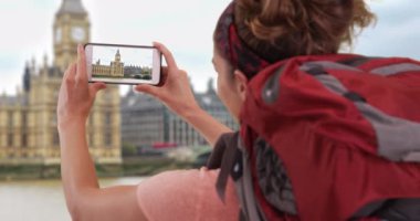 İngiltere, Londra 'yı keşfeden genç bir bayan Big Ben' in dışarıda cep telefonuyla bir videosunu kaydediyor. Beyaz kadın turist Big Ben 'in akıllı telefondaki videosunu çekiyor. 4k