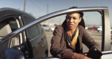 Siyahi bir kadının arkadaşıyla konuşurken ve elinde bir cep telefonu tutarken çekilmiş bir fotoğrafı.