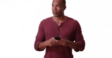 Siyah bir adam beyaz arka planda cep telefonuyla mesaj atıyor. Afrikalı bir Amerikalı akıllı telefonunu boş bir fon üzerinde kullanıyor. 4k