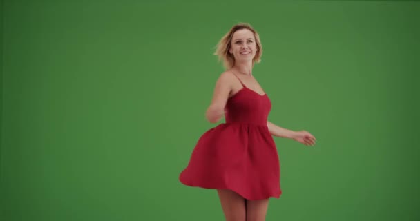 穿着红色衣服在绿色荧幕上跳舞的无忧无虑的女人 在绿色屏幕上键入或合成 — 图库视频影像