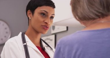 Genç akıllı kadın doktor yaşlı hasta için konuşuyor