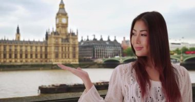 Londra 'da tatilde olan sevimli Japon kadın portresi. Big Ben saat kulesinin yanında duran mutlu çekici turist. 4k