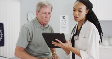 Afrikalı kadın doktor ofisi üst düzey hastayla konuşuyor
