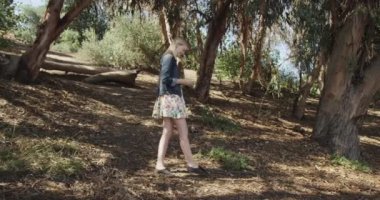 Açık havada akıllı telefon kullanan genç sarışın kadın.