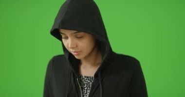 Kapüşonlu genç bir kız yeşil ekranda kameraya gülümsüyor. Anahtar ya da birleşik olmak üzere yeşil ekranda.