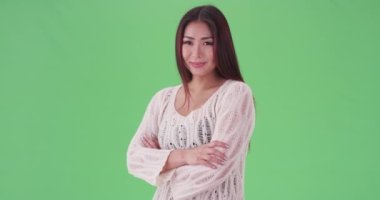 Asyalı kadın yeşil ekranda gururla duruyor. Anahtar ya da birleşik olmak üzere yeşil ekranda.