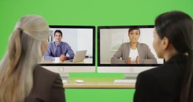 İki iş kadını iş arkadaşlarıyla yeşil ekranda konferans görüşmesi yapıyor. Anahtar ya da birleşik olmak üzere yeşil ekranda.