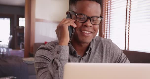 Czarny Mężczyzna Okularach Rozmawia Przez Telefon Pracując Laptopie Afroamerykanin Używa — Wideo stockowe