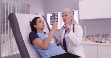 Kıdemli beyaz kadın doktor İspanyol sporcuların sakatlıklarına danışmanlık yapıyor.