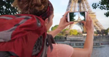 Paris 'teki beyaz kadın gezgin cep telefonuyla Eyfel Kulesi' nin fotoğrafını çekiyor. Paris 'i gezen kahverengi saçlı genç bayan Eyfel Kulesi' nin fotoğrafını çekiyor. 4k