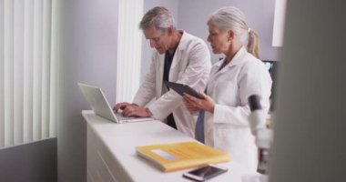 Meslektaşımla konuşurken, kıdemli erkek doktor daktilo kullanıyor.