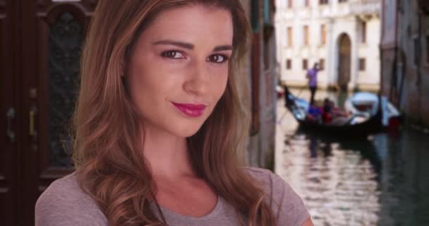 かなり若い女性は ヴェネツィア イタリアのカメラで優しく笑みを浮かべて旅行 女性白人観光客は自信を持って彼女の休暇にヴェネツィアを探索します — ストック動画