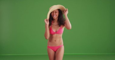 Yeşil ekranda bikini giymiş, gülümseyen melez bir kadın. Anahtarlama veya birleştirme için yeşil ekranda.
