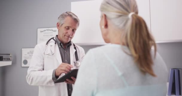 Médico Mediana Edad Que Consulta Paciente Con Tableta — Vídeos de Stock