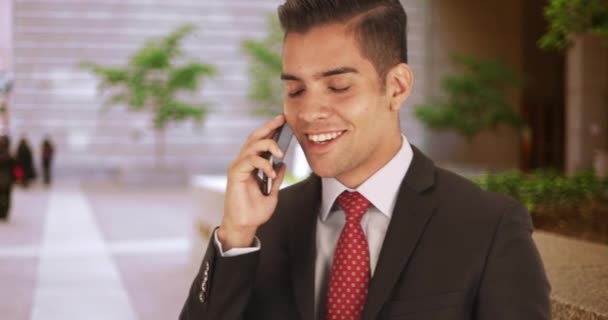 年轻的西班牙裔商业专业人士在办公楼外用智能手机交谈 千年拉丁商人使用智能手机打电话 — 图库视频影像