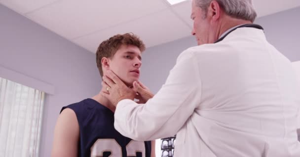 中年医生检查篮球运动员运动颈部受伤情况 — 图库视频影像