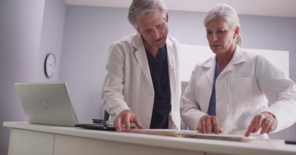 Deux Médecins Caucasiens Lisant Dossier Patient — Video
