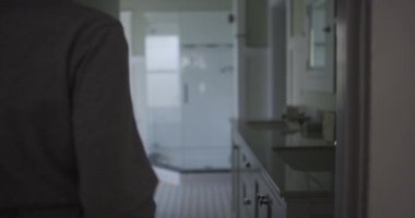 Çekici, genç, İspanyol bir kadın tuvalette yürüyor.