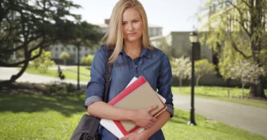 Sessiz bir okul kampüsünde duran sevimli genç kız öğrenci.