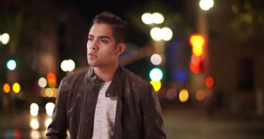 Milenyum modasına uygun İspanyol bir adam gece sokakta dikiliyor. Akşamları deri ceket giyen yakışıklı Latin adamın portresi. 4k