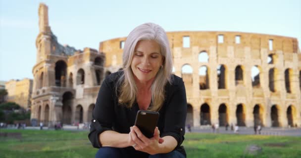 Ευγενική Γριά Λευκή Κυρία Χρησιμοποιεί Τηλέφωνό Της Μπροστά Από Ρωμαϊκό — Αρχείο Βίντεο